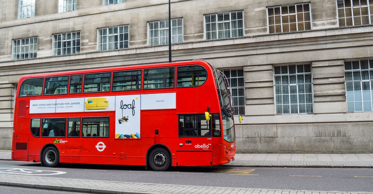 Public transport UK - Red double decker bus following on street