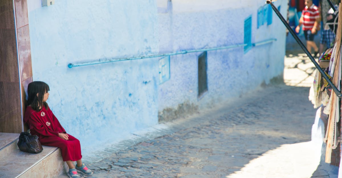 Public transportation considerations for children in North Eastern USA - Girl sitting on street stairs in indigenous outdoor market