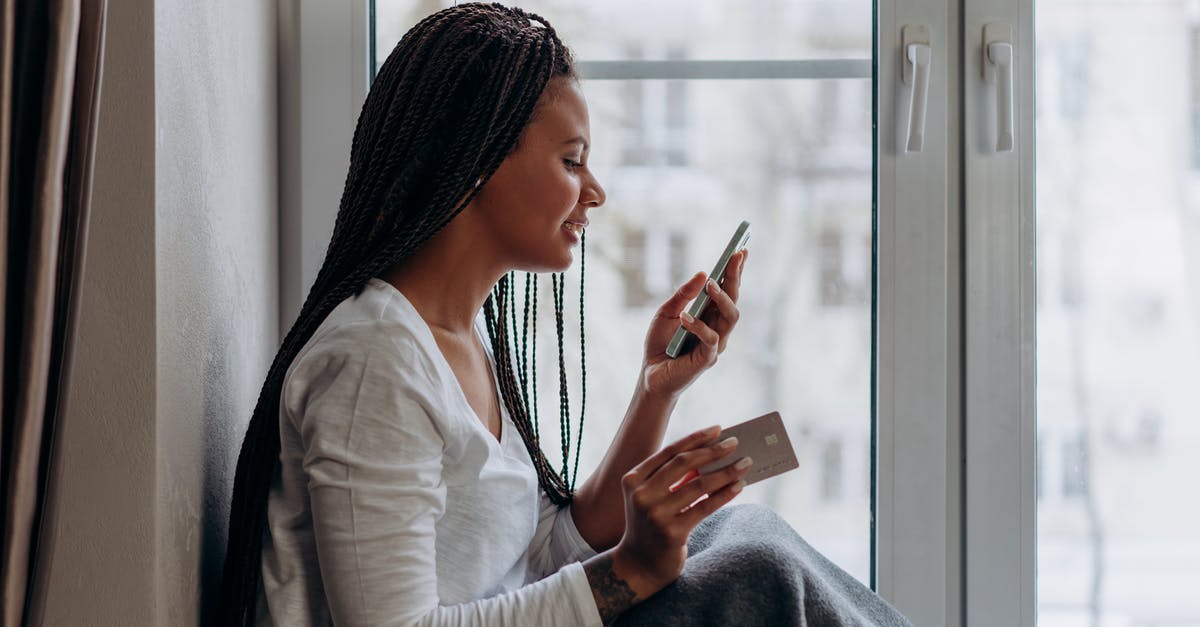 Purchasing monthly personalised Tallinja Cards - A Woman Talking on the Phone Holding a Credit Card