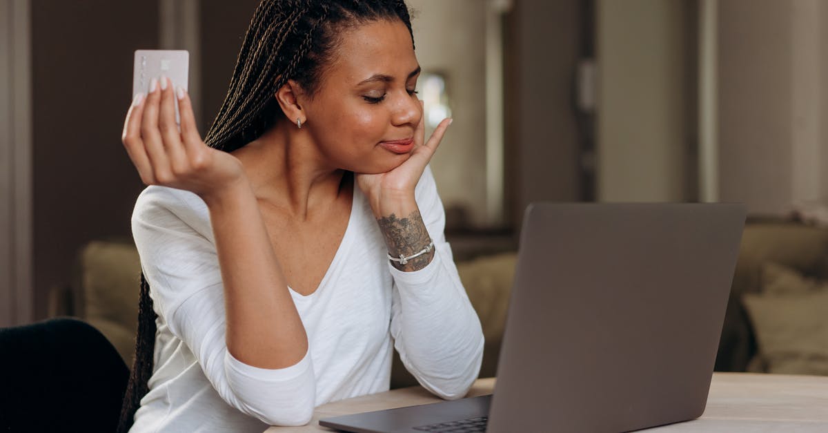 Purchasing monthly personalised Tallinja Cards - A Woman Sitting at Table with Laptop Holding a Credit Card