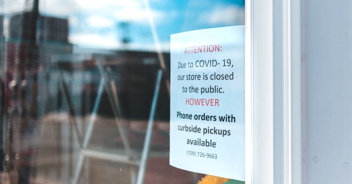 Quarantine Rule in New York - Paper sheet with warning information on glass wall of local city shop with portable ladder inside reflecting blue cloudy sky during quarantine period