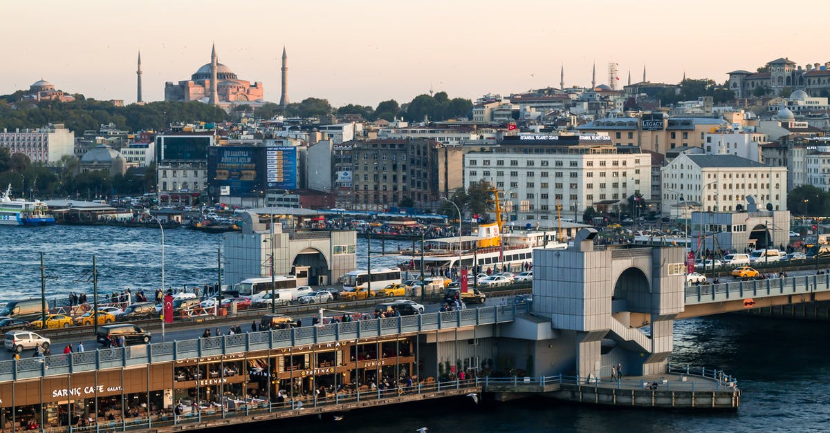 Quickest way from Istanbul to Krakow - Bridge with cars crossing rippling sea near shore with coastal city with residential houses and historic buildings on summer day