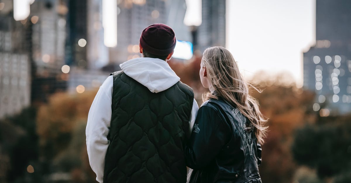 Quiet cities close to Brussels and Amsterdam - Back view of young couple standing on blurred background of city and enjoying moment