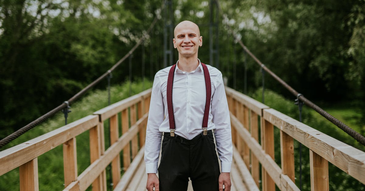 "Airport-friendly" suspenders (braces) with AIT - Man in White and Red Long Sleeve Shirt and Black Pants Standing on Brown Wooden Bridge