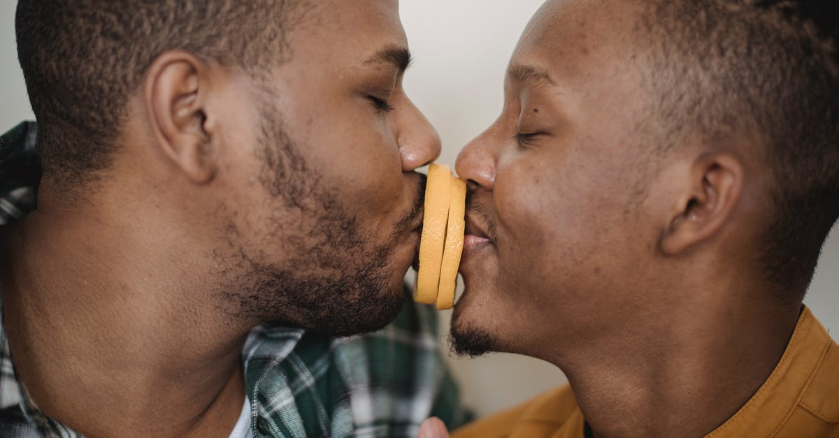 "Cheek kissing" between men in Mongolia - Two Men Kissing With Orange Slices Between Them