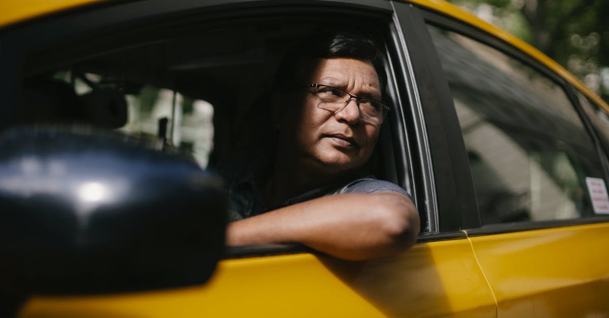 Radio program with public transport focus by country - Serious ethnic male driver looking at opened window of taxi