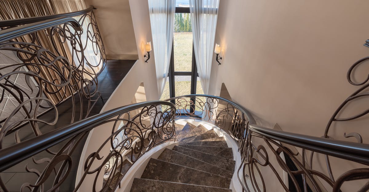 Rail Baltica, Warsaw-Kaunas segment - From above of stairway with marble steps and metal railings with ornamental elements located near window with tulle in contemporary building