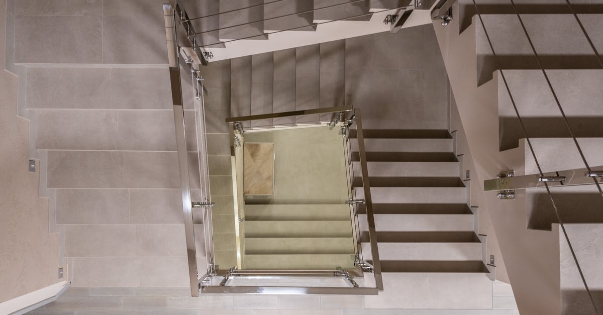 Rail Baltica, Warsaw-Kaunas segment - Top view flights of stairs with metal handrails and fencing located in light modern spacious multistory building with laminate floor