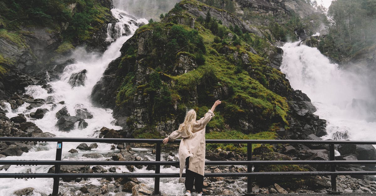 Rail travel in Switzerland Easter Weekend - Unrecognizable female tourist enjoying view of waterfall in mountains