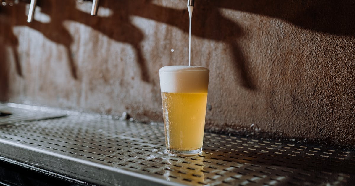 Received gestures in UK pubs: pint versus half-pint - Beer Pouring Into Clear Drinking Glass on Metal Surface