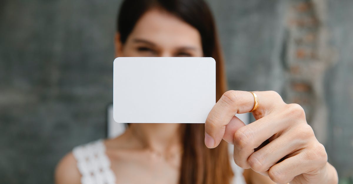 Recommendation for prepaid SIM card in the Netherlands - Young blurred female showing white blank business card and looking at camera in light room