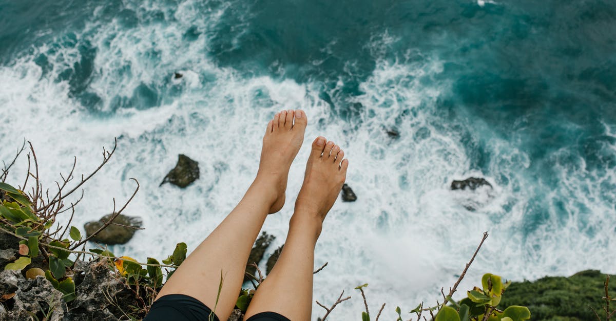 Recreating Hemingway's Trip to Pamplona (Part 1) - Woman sitting on edge of cliff above foaming sea