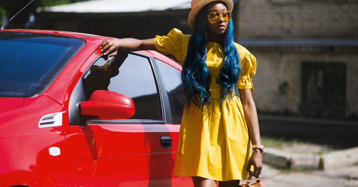 Red triangle, yellow jackets, etc. for rental cars in France - Woman Standing Beside Red Car