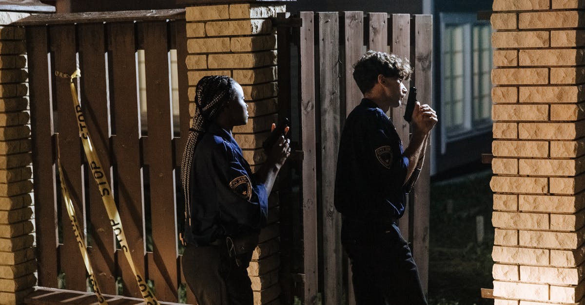 Re-entering Canada after minor contact with the police there - Police Officer Entering a House While Holding Guns 