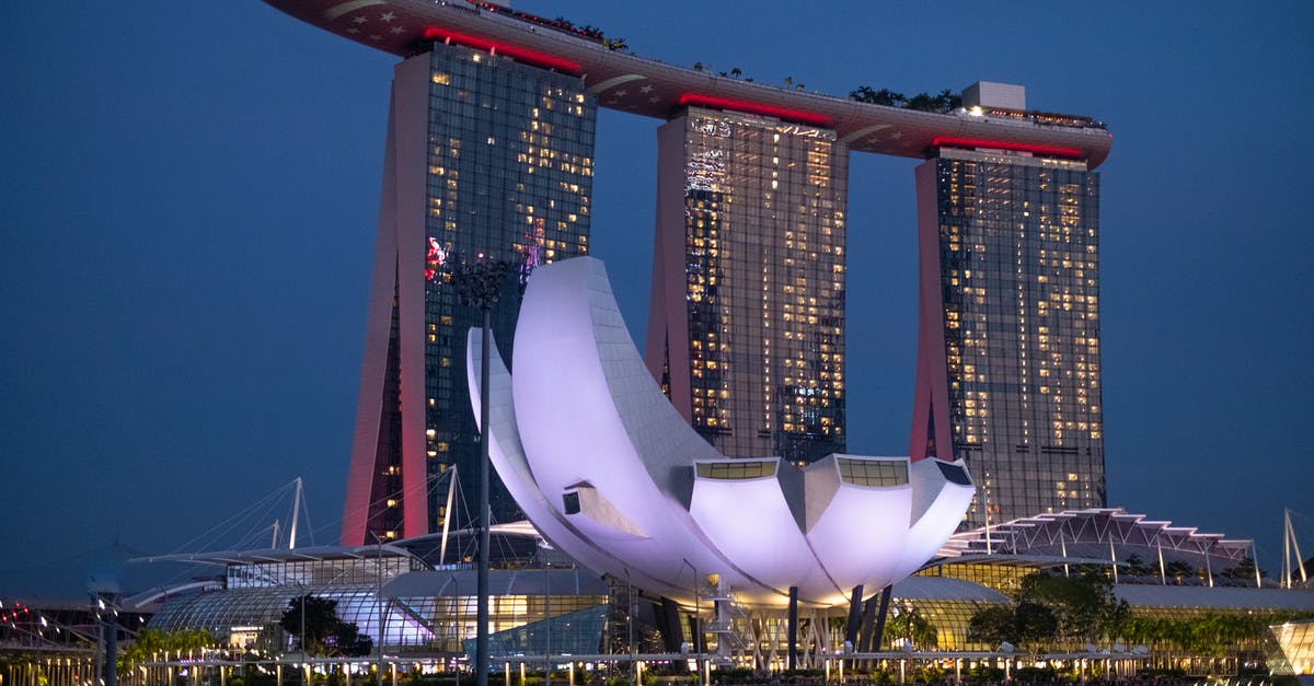 Re-entering Singapore on a multiple-entry visa - White and Red Building Near Body of Water during Night Time