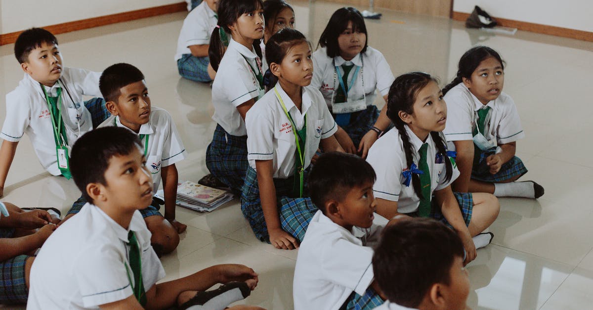 Re-entering the UK have short-term student child unaccompanied visa - Children in School Uniforms Sitting on Floor in Classroom