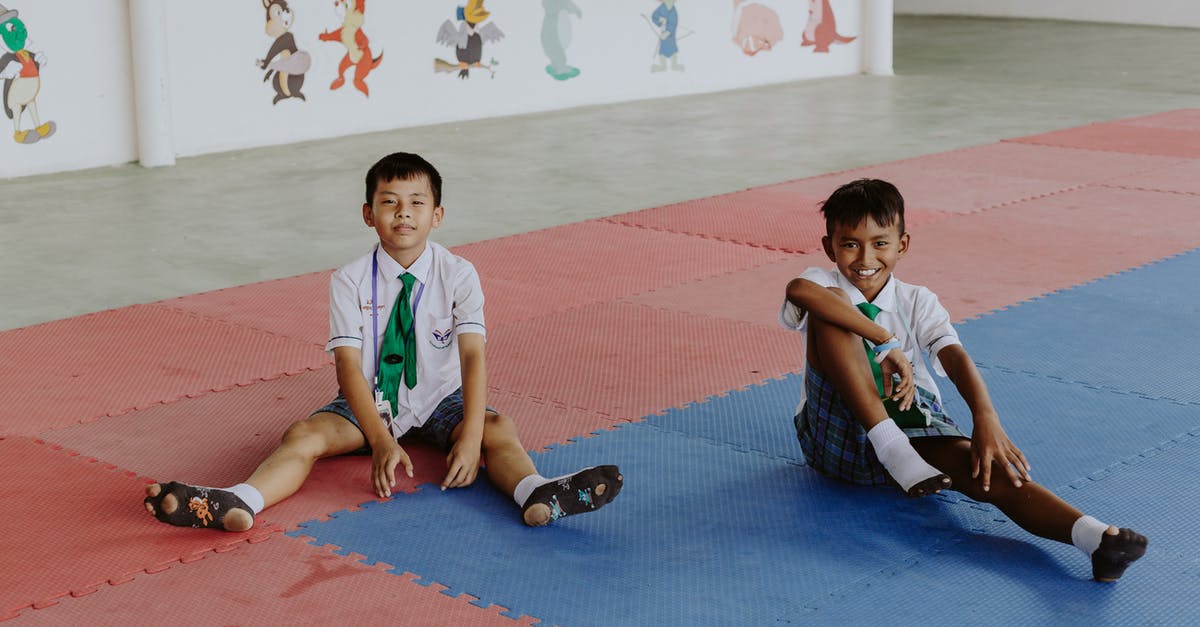 Re-entering the UK have short-term student child unaccompanied visa - Portrait of Smiling Boys in School Uniforms Sitting in School Gymnasium