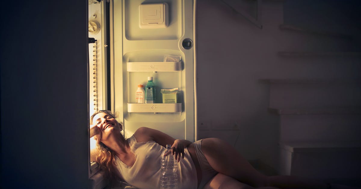 Refrigerator 60 Hz vs 50 Hz [closed] - Photo of Smiling Woman in White Vest and Panties Lying on Floor Next to Open Fridge with Her Eyes Closed