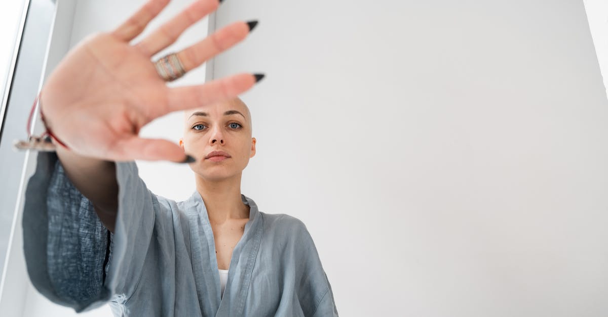 Refuse to answer questions at border control - Patient showing stop gesture in light clinic