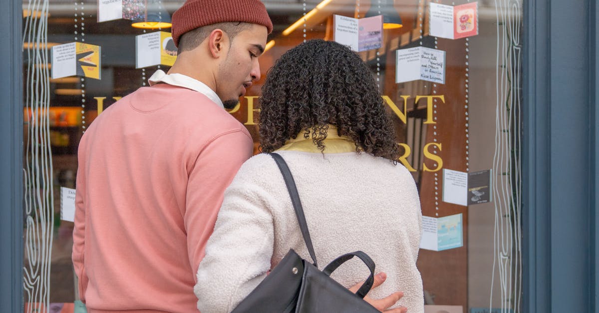 Refused entry to Spain previously. Will this affect my Student visa application? [closed] - Back view of young Hispanic couple in stylish clothes cuddling while standing near glass showcase of bookstore during weekend in city