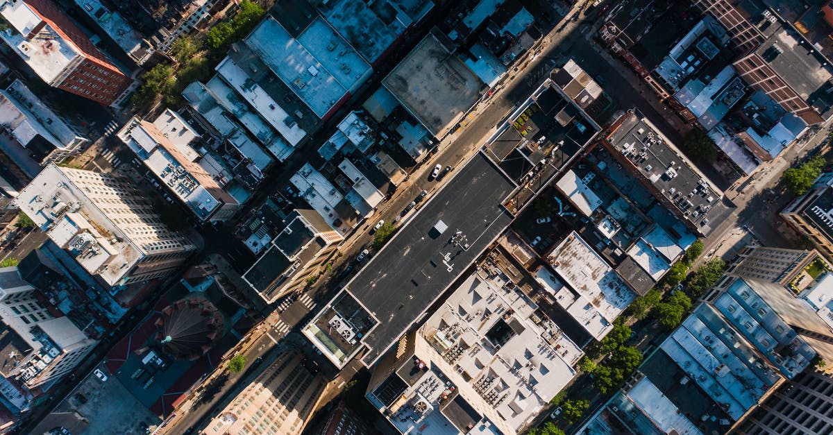 Rent a car in Greece (Thessaloniki) and drive to Macedonia - Aerial view of typical apartment buildings with automobiles driving along road in residential district