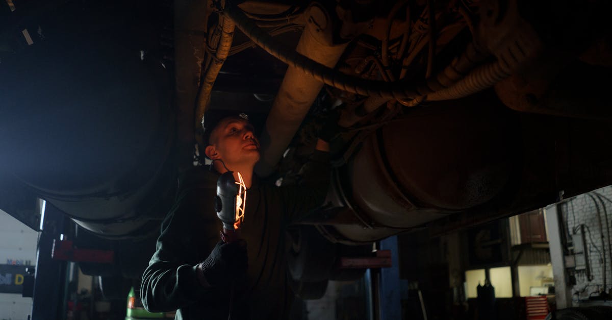 Renting a car in Israel when under 21? - A Man Holding a light Checking Under a Vehicle