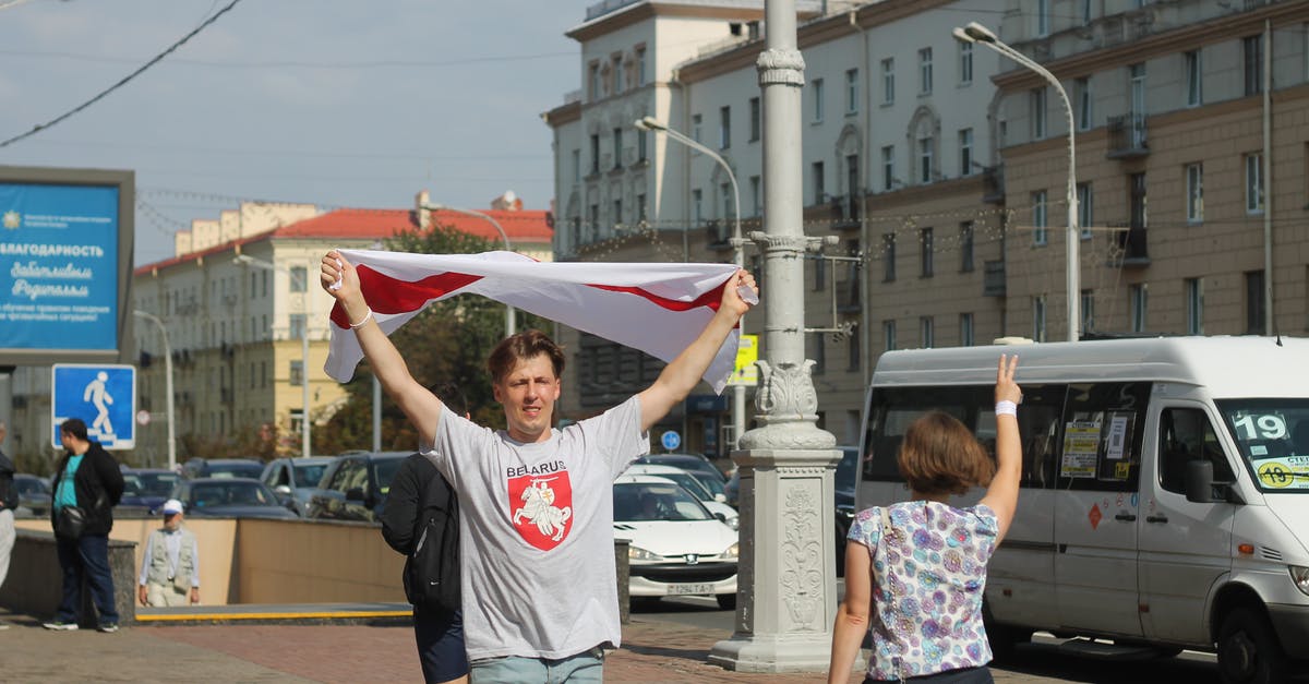 Renting a car in Minsk, Belarus for EU citizens - A Man Walking on the Street Carrying a Flag