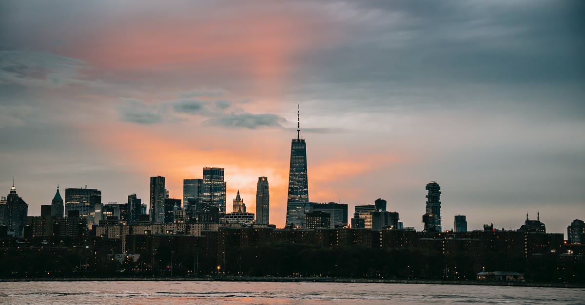 Renting a car on the east coast USA - Modern New York City district with famous typical skyscrapers situated on East River coast at picturesque sunset