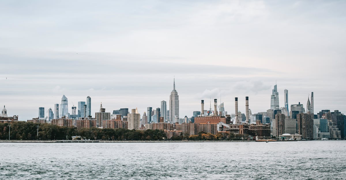 Renting a car on the east coast USA - Scenery of New York cityscape with modern urban architecture situated on rippling East River coast on clear weather