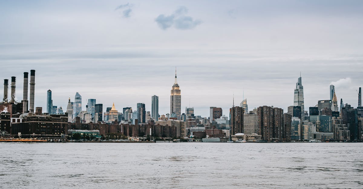 Renting a car on the east coast USA - Cityscape of contemporary New York City district with famous skyscrapers situated on East River shore under clear sky