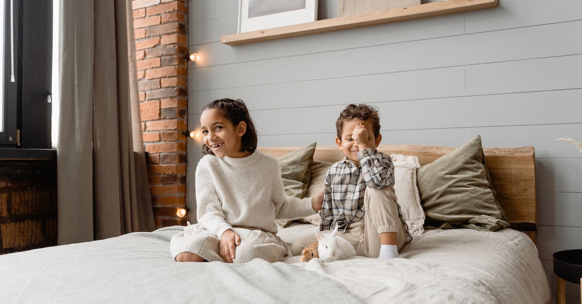 Renting a holiday house in the Riviera with a small child - Woman in Gray Sweater Sitting on Bed Beside Woman in Gray Sweater