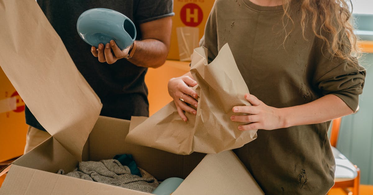 Renting room in Madrid [closed] - Crop faceless young woman and man unpacking belongings after moving in new house