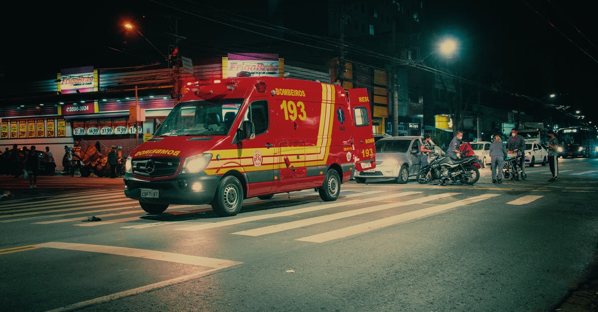Re-routing and assistance rights for delayed Interrail/Eurail passengers - Red emergency transport near  car crash on illuminated night street in modern city