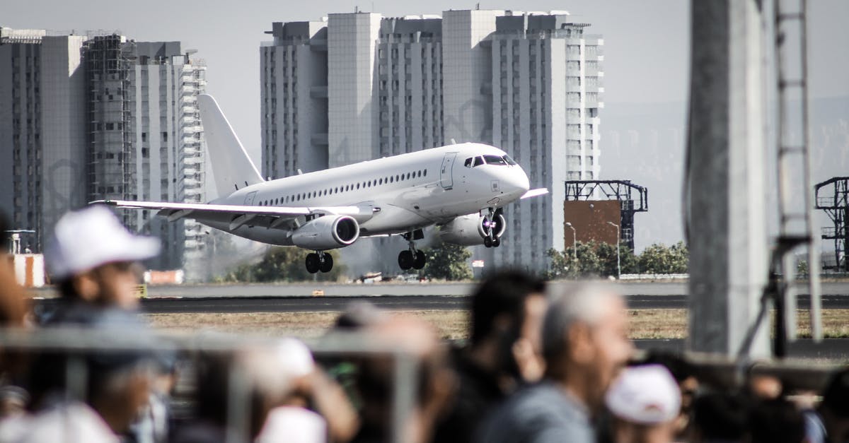 Rescheduled flight - People Walking on the Street Near White Airplane