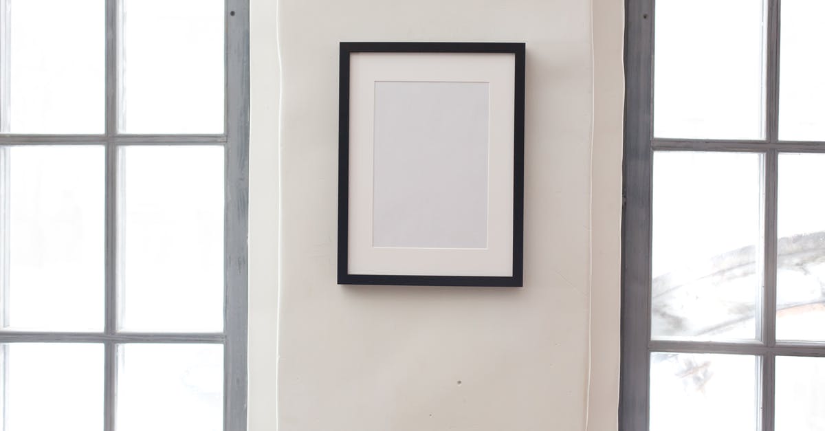 Retrieving Bags To Clear Customs/Lounge Access Upon Arrival - Interior of simple apartment with blank frame on white wall between rectangular shaped windows