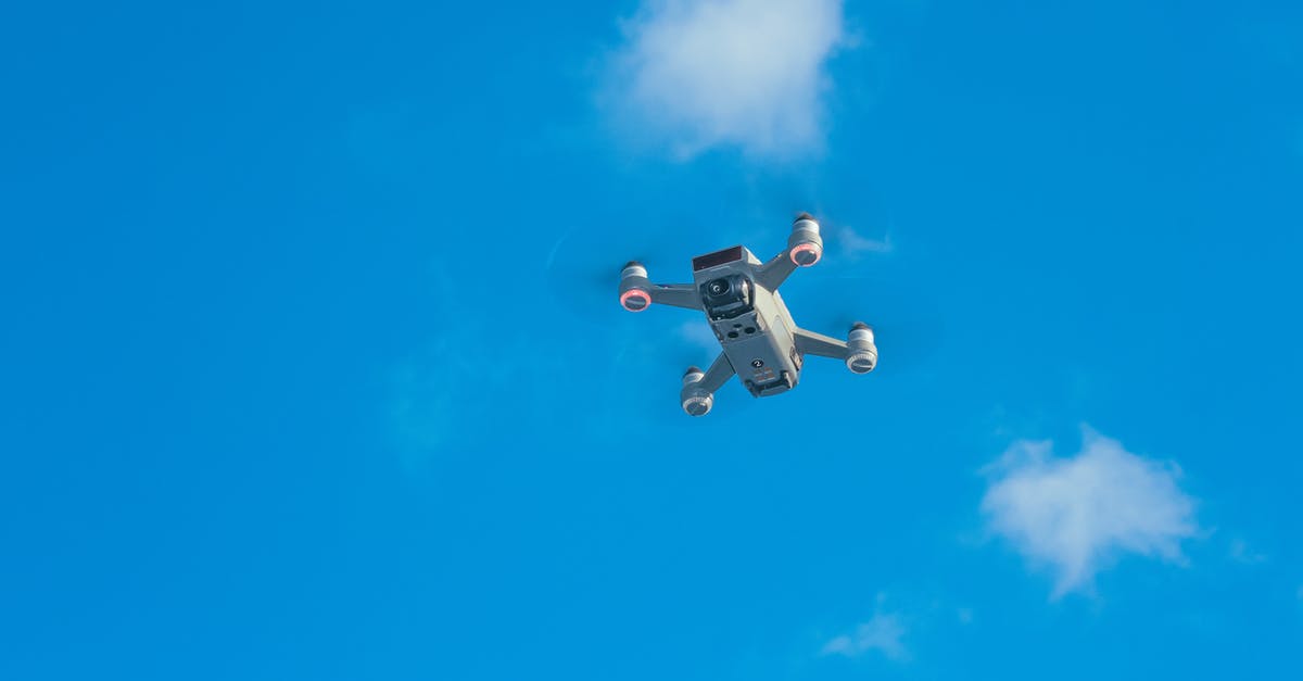 Retrieving checked bags from a connecting flight - White uav with spinning motors in air