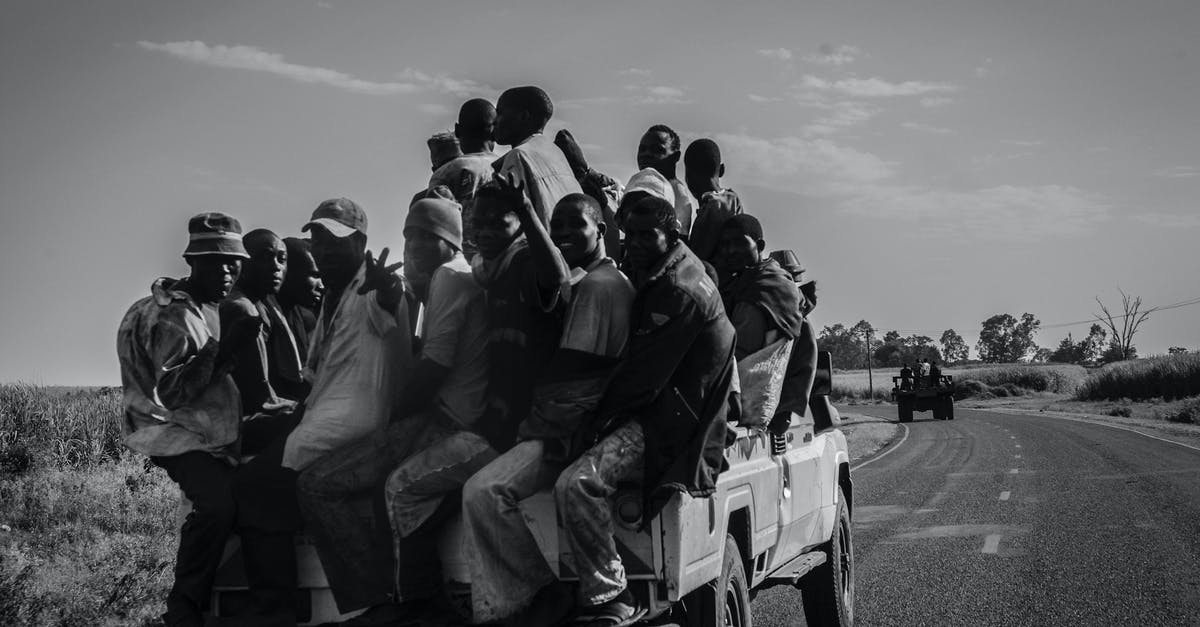 Returning back to UK - Grayscale Photo of People Sitting on Car