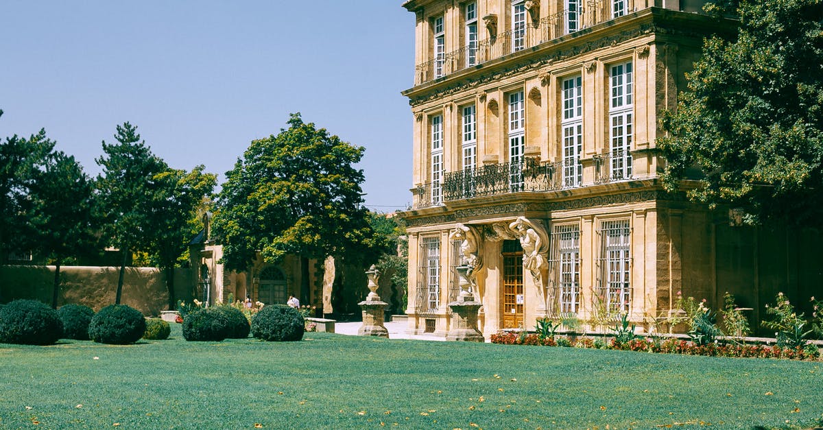 Returning to France as a resident - Old building with green lawn and bushes