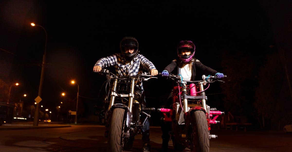 Riding an Abra at Night (Dubai) - A Man and a Woman Riding Their Motorcycles at Night