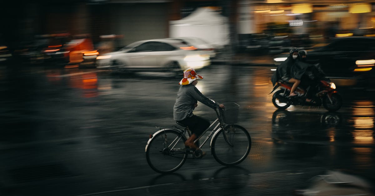 Riding an Abra at Night (Dubai) - A Person Riding a Bicycle while Wearing a Hat