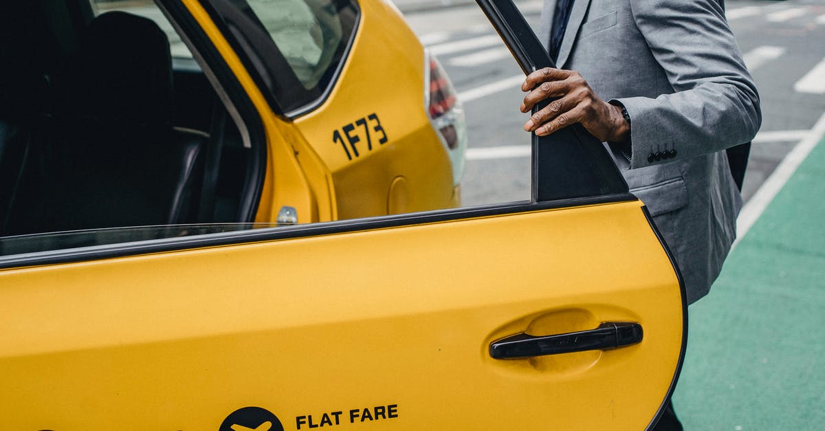 Roland-Garros (French Open) public viewing in Paris? - Side view crop anonymous African American male wearing classy jacket opening yellow taxi door parked on busy city street