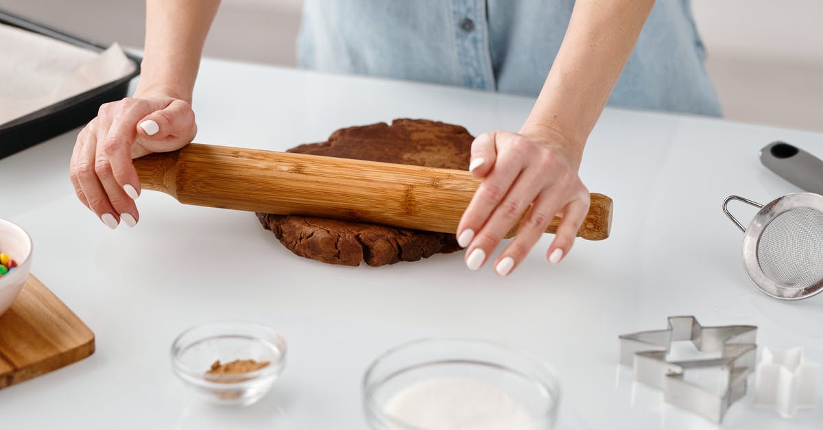 Rolling shirts in a bundle VS laying them flat while packing? - Person Flattening a Chocolate Dough With Rolling Pin