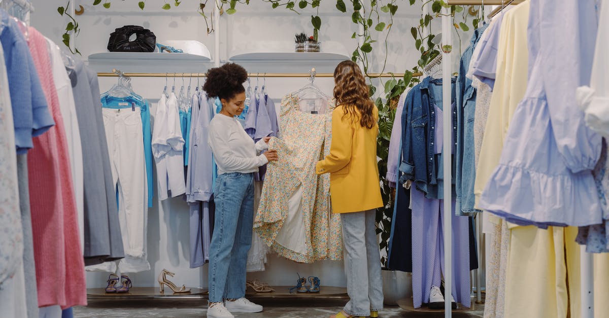 Routing Choices in the Balkans - Woman in White Long Sleeve Shirt and Gray Pants Standing Beside Woman in Yellow Long Sleeve