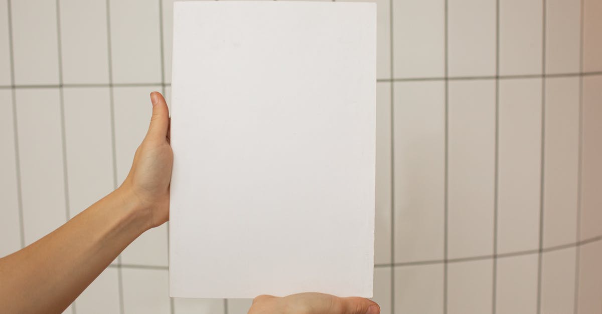 Russia roadmap with information on the surface - Crop faceless person showing empty sheet of paper with tiled wall on background