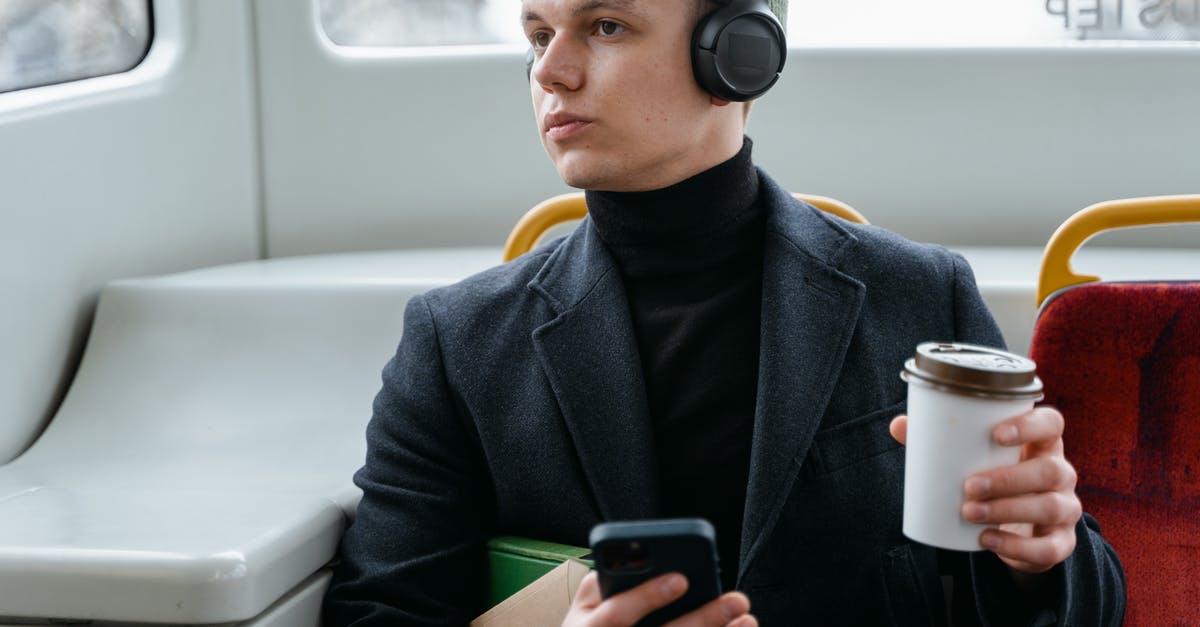 Russian train ticket for the World Cup - Man Listening to Music and Holding a Cup of Coffee 