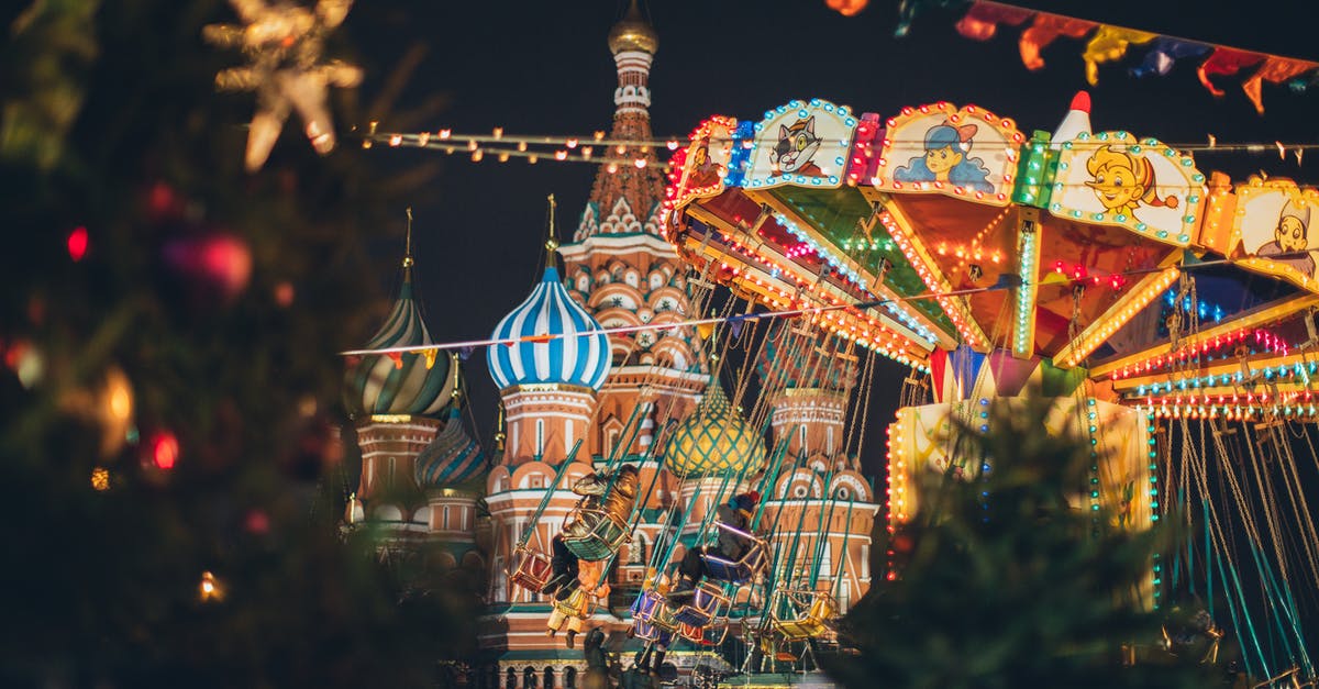 Russian visas and short-term apartment rental in St Petersburg and Moscow - Colorful carousel against Cathedral on Red Square at New Year night
