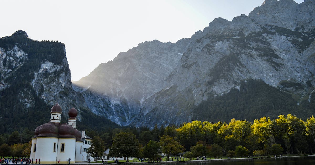 Sacred mountains in Japan? - Picturesque scenery of rippling clean lake with peaceful embankment covered with trees and old church