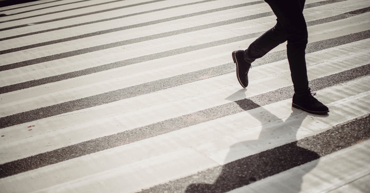 Safe place to cross border from Mexico into U.S.? - Crop faceless person in elegant black trousers and shoes walking on crosswalk in daytime