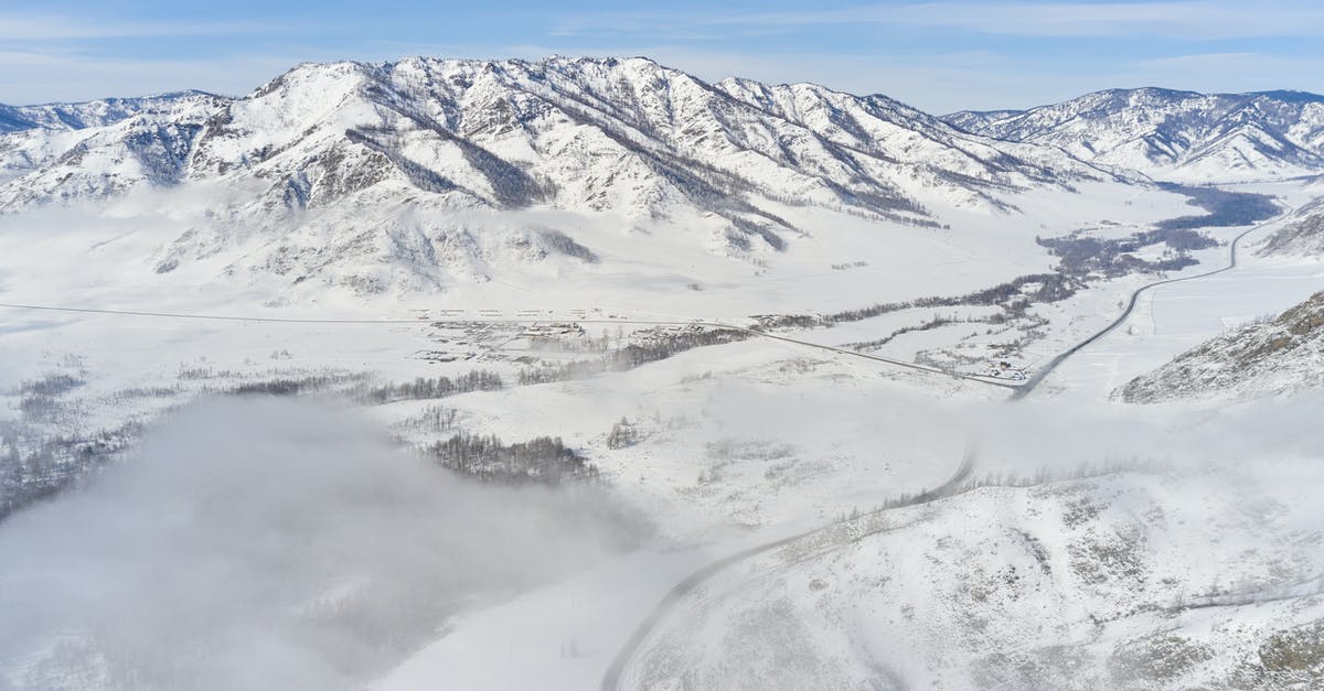 Safe route through Death Valley to Vegas? - Snowy road and river in valley among mountains in winter