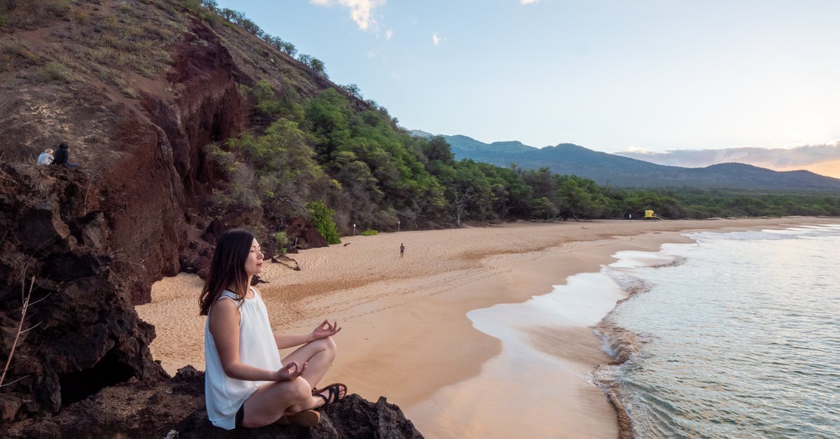 Safeguarding against extra expenditures Natural disasters during travels - Young ethnic woman meditate on empty beach